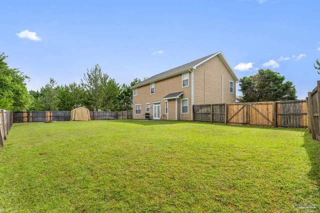 a view of a house with backyard and garden
