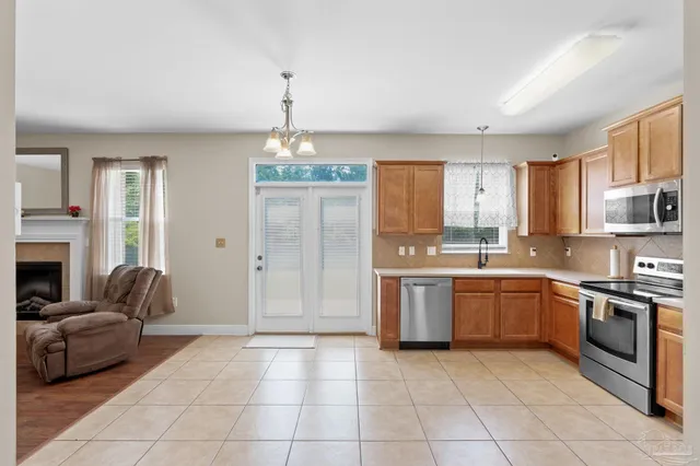 a large kitchen with cabinets a sink and stainless steel appliances