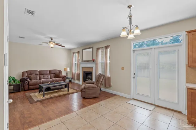 a living room with furniture a fireplace and a chandelier