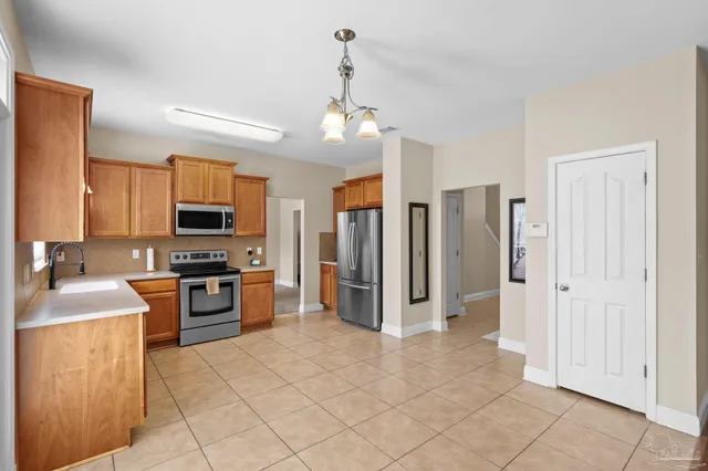 a kitchen with stainless steel appliances granite countertop a refrigerator a stove top oven a sink and dishwasher