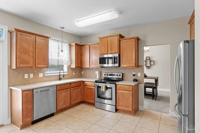 a kitchen with stainless steel appliances granite countertop a stove top oven a sink and dishwasher a refrigerator