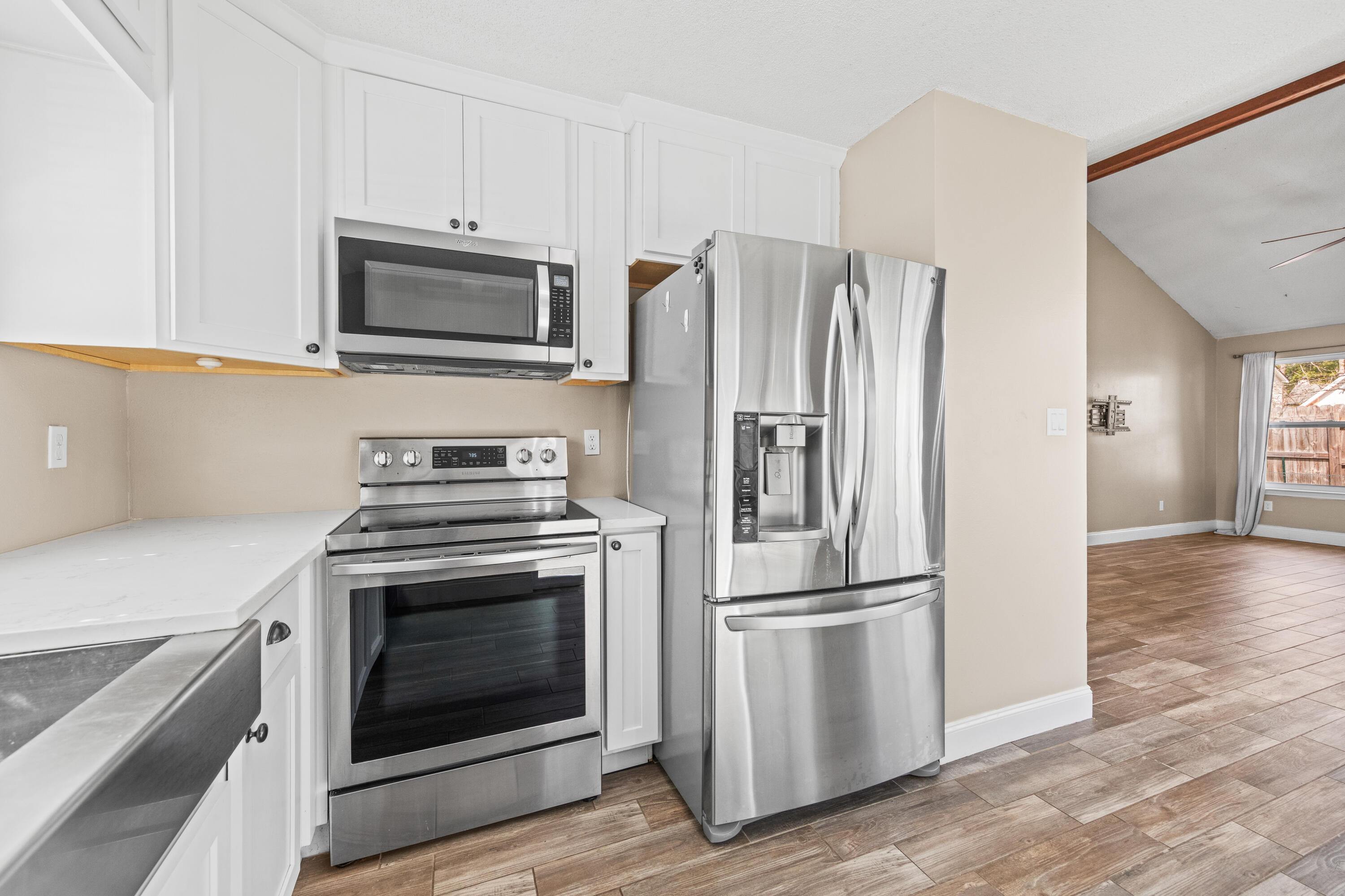 1833 Hunters Path Fort Walton Beach, FL 32547 - Photo 18 of 43 a kitchen with white cabinets stainless steel appliances and wooden floor