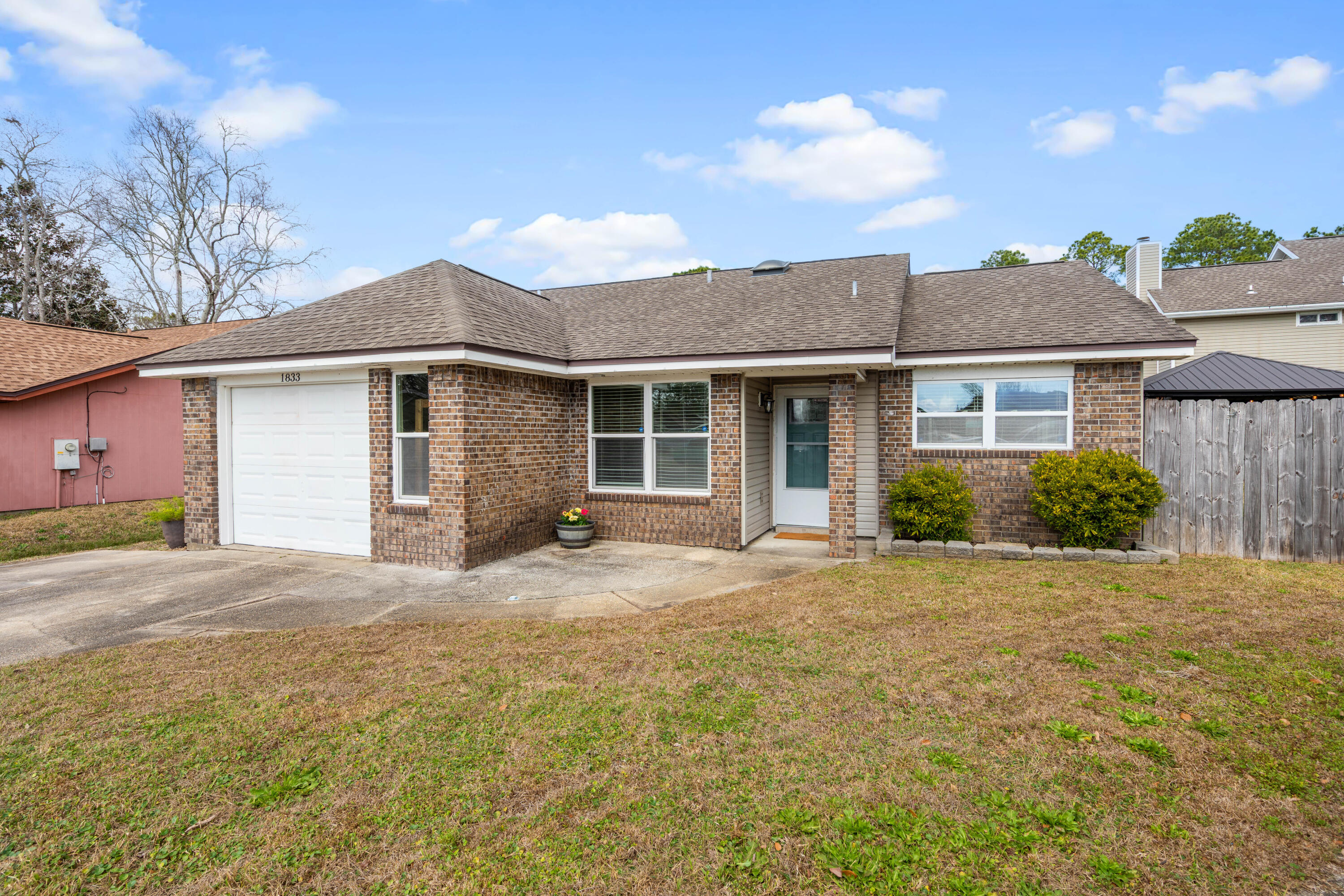 1833 Hunters Path Fort Walton Beach, FL 32547 - Photo 2 of 43 a front view of a house with a garden and yard