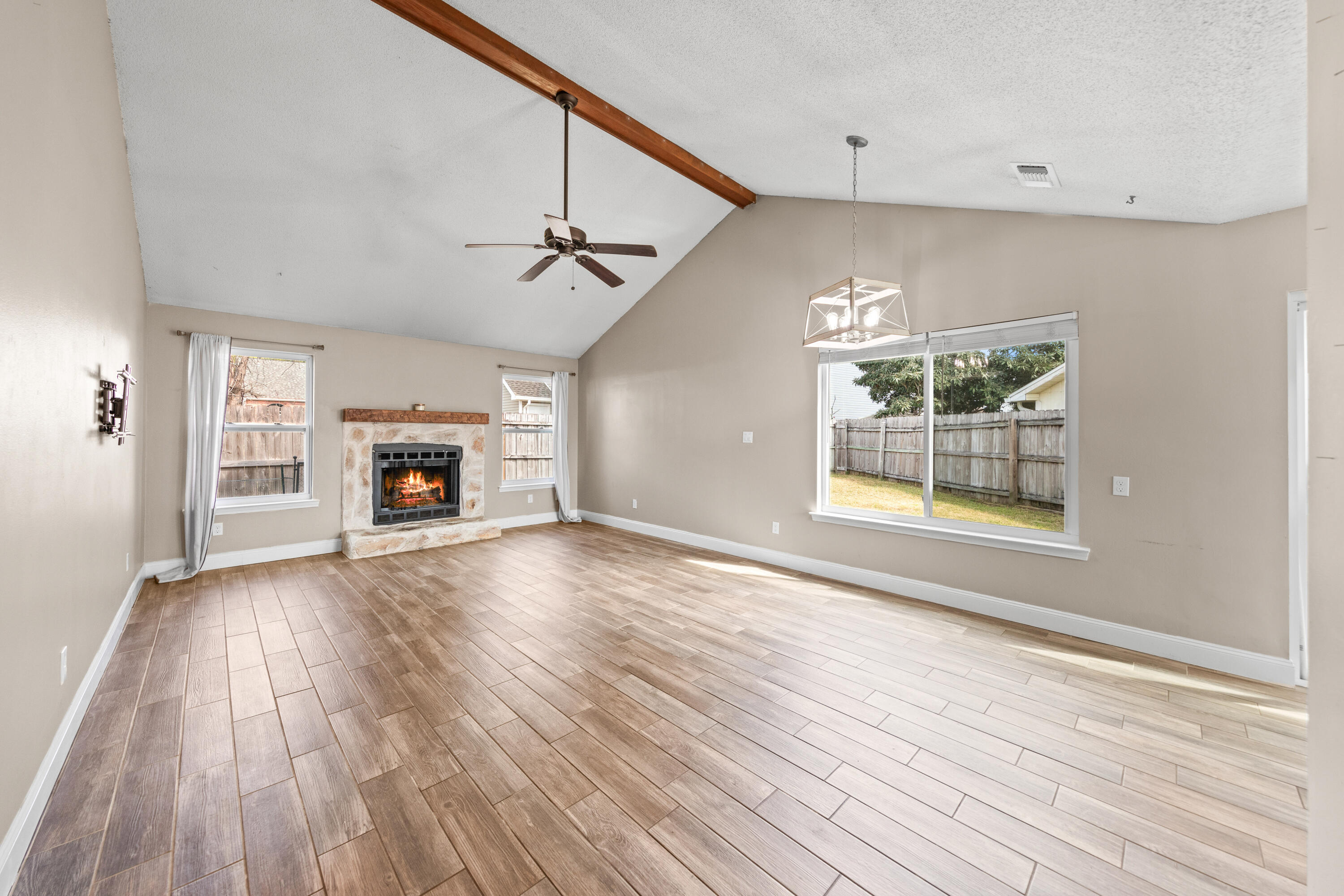 1833 Hunters Path Fort Walton Beach, FL 32547 - Photo 8 of 43 an empty room with windows fireplace and wooden floor