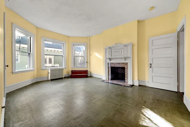 a view of an empty room with a fireplace and a window
