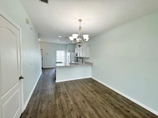 a view of a livingroom with wooden floor and a chandelier