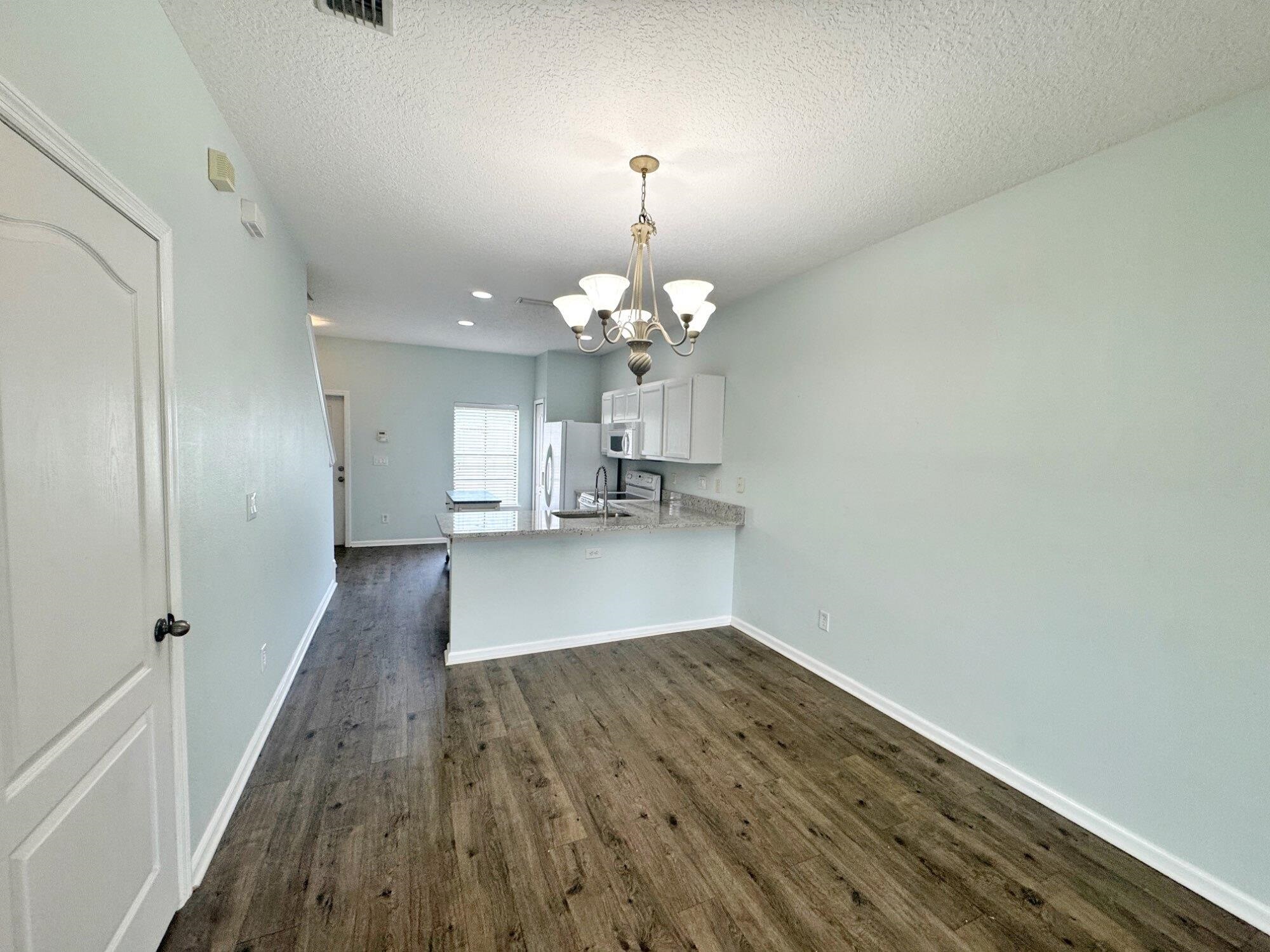 237 Syrah Way St. Augustine, FL 32084 - Photo 11 of 26 a view of a livingroom with wooden floor and a chandelier