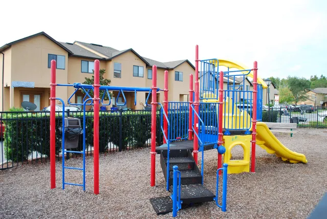 a view of sitting area with large trees and plants
