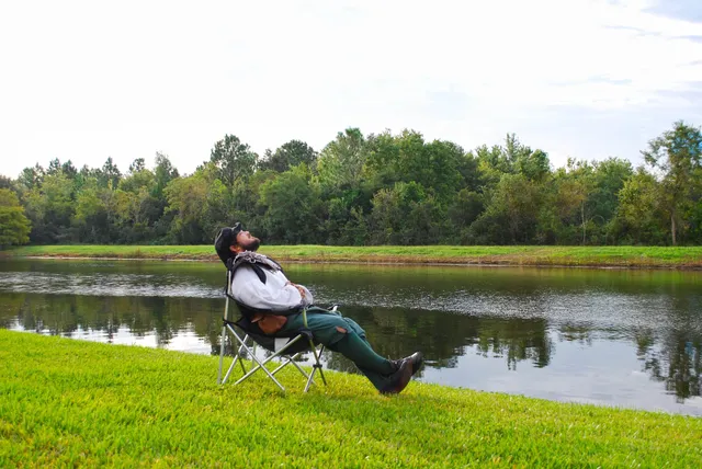 a view of a lake with a yard and large trees