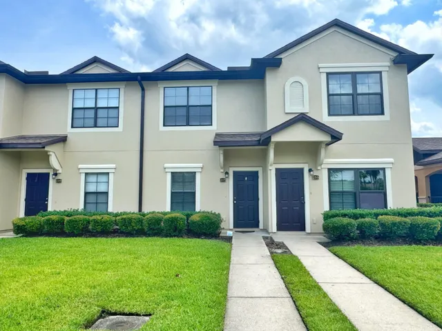 a front view of a house with yard and green space