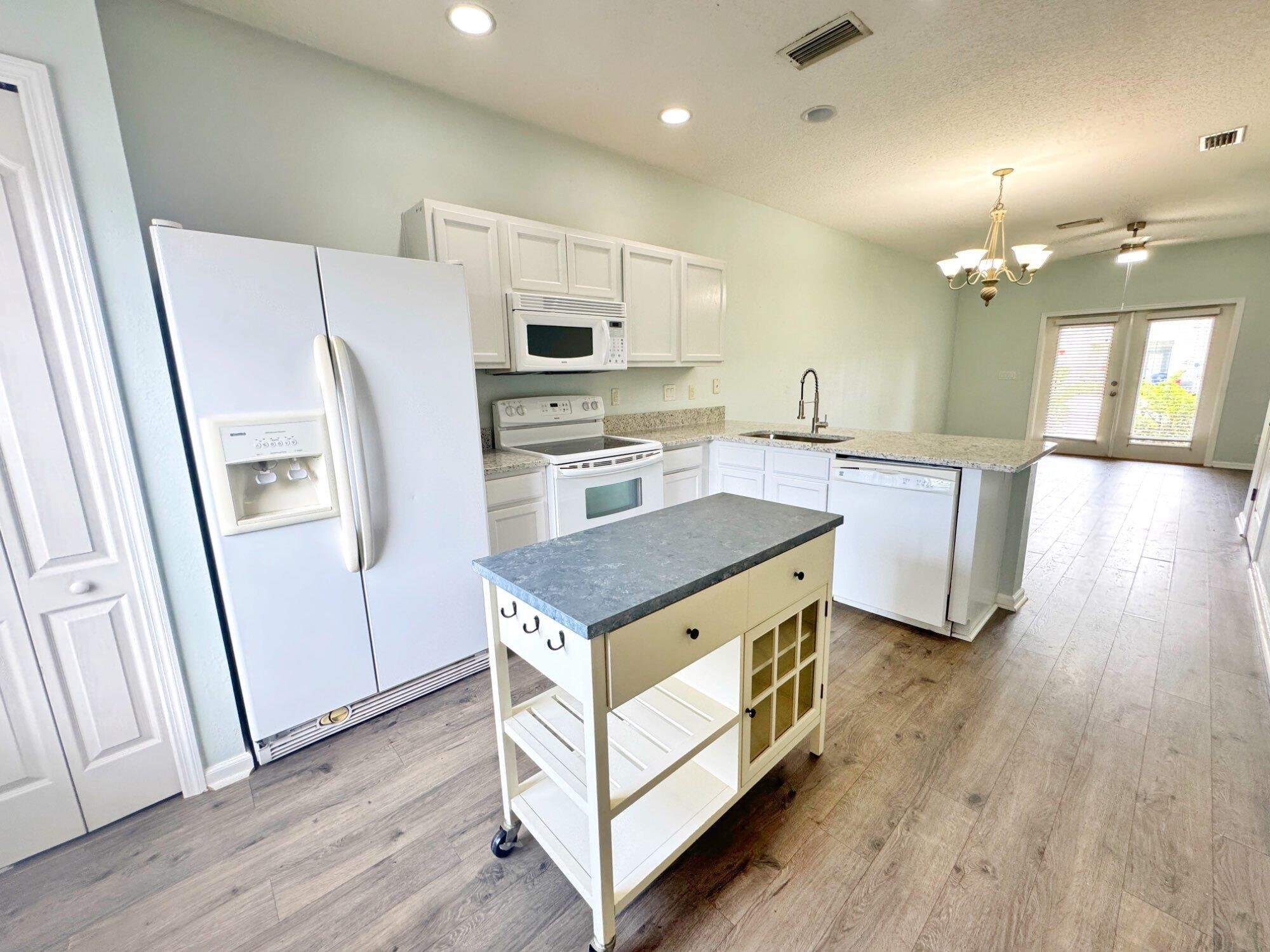 237 Syrah Way St. Augustine, FL 32084 - Photo 4 of 26 a kitchen with stainless steel appliances a stove a refrigerator a sink a oven with wooden floor and cabinets