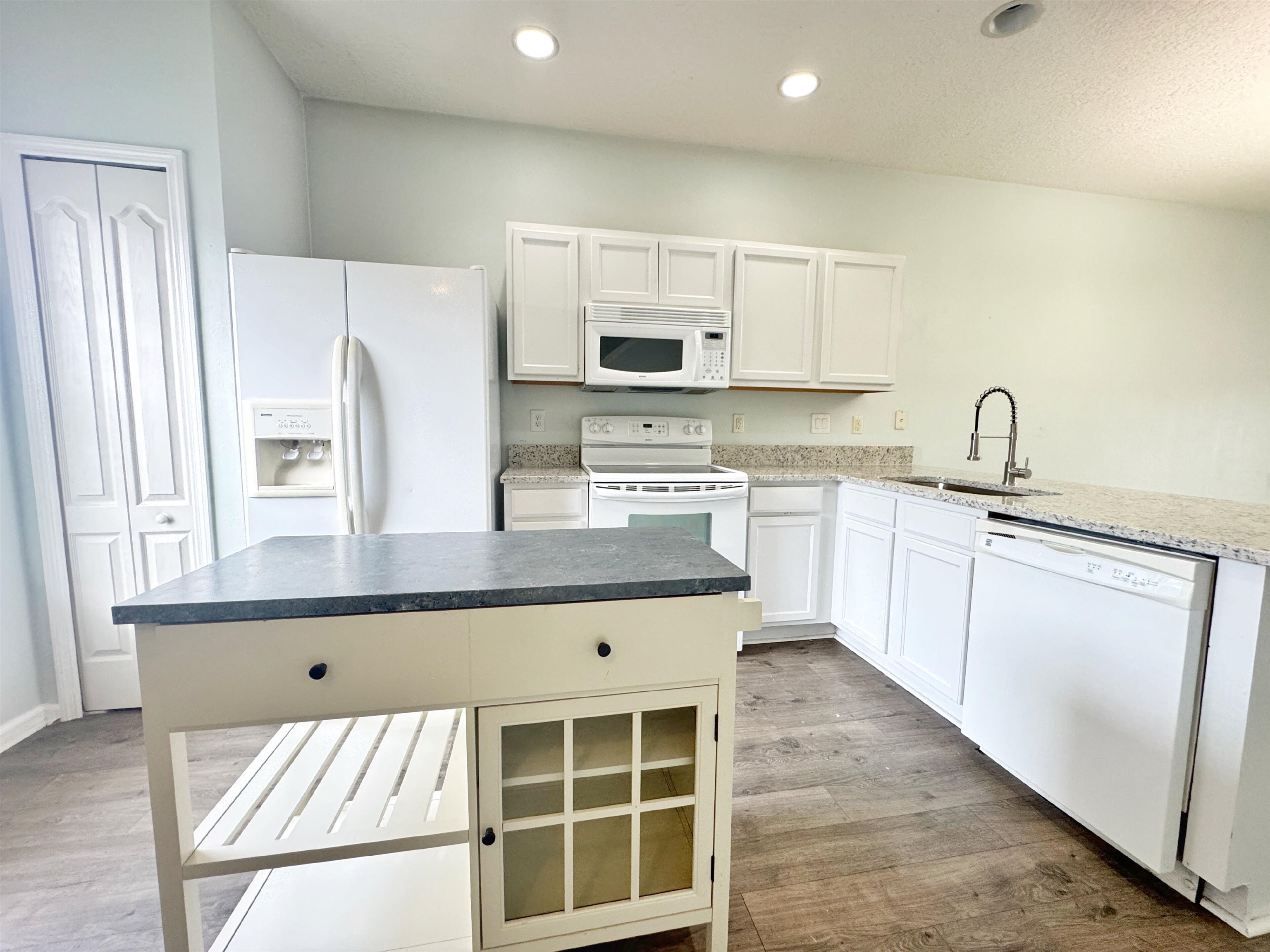 237 Syrah Way St. Augustine, FL 32084 - Photo 6 of 26 a kitchen with stainless steel appliances granite countertop a stove a sink dishwasher and a refrigerator with wooden floor