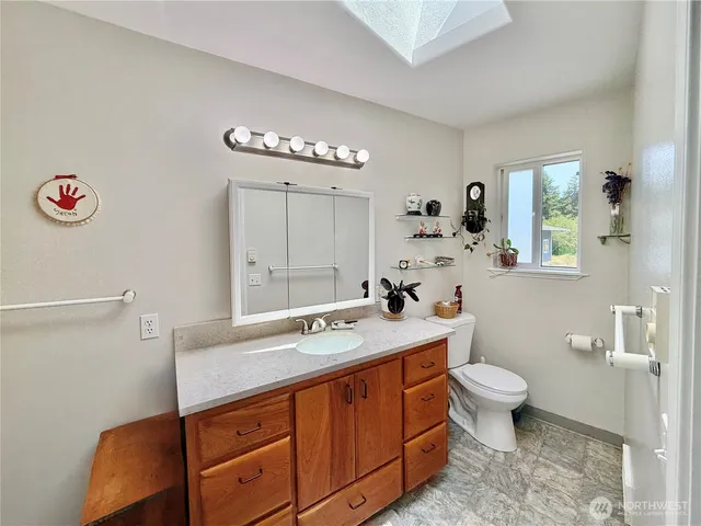 a bathroom with a sink a toilet and a mirror
