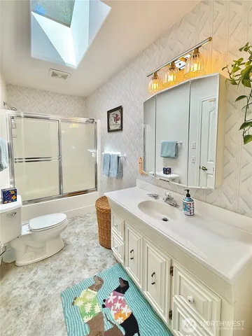 a spacious bathroom with a double vanity sink toilet and a mirror