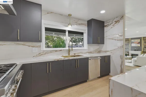 a kitchen with stainless steel appliances granite countertop a sink stove and refrigerator