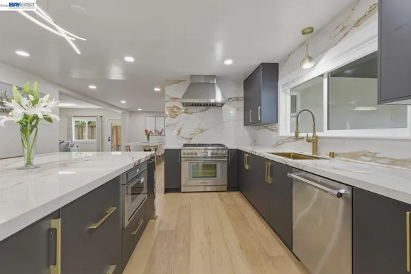 a large kitchen with stainless steel appliances granite countertop a sink and stove top oven