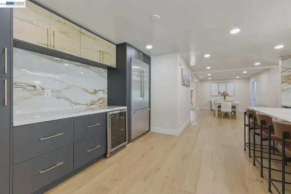 a open kitchen with kitchen island a sink white cabinets and stainless steel appliances