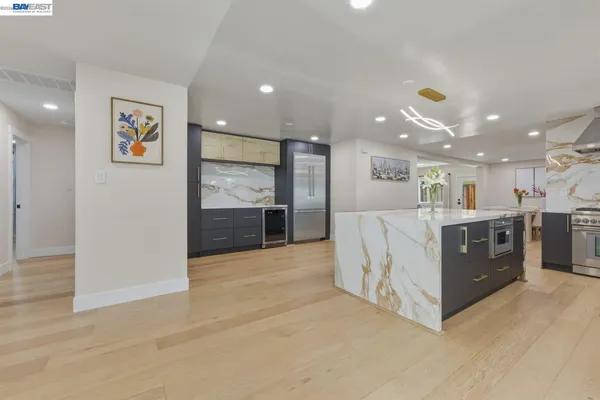 a large room with a large counter top and stainless steel appliances