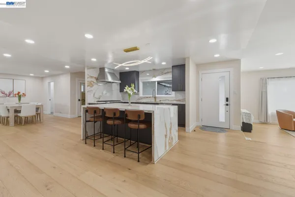 a kitchen with stainless steel appliances kitchen island granite countertop a table and chairs in it