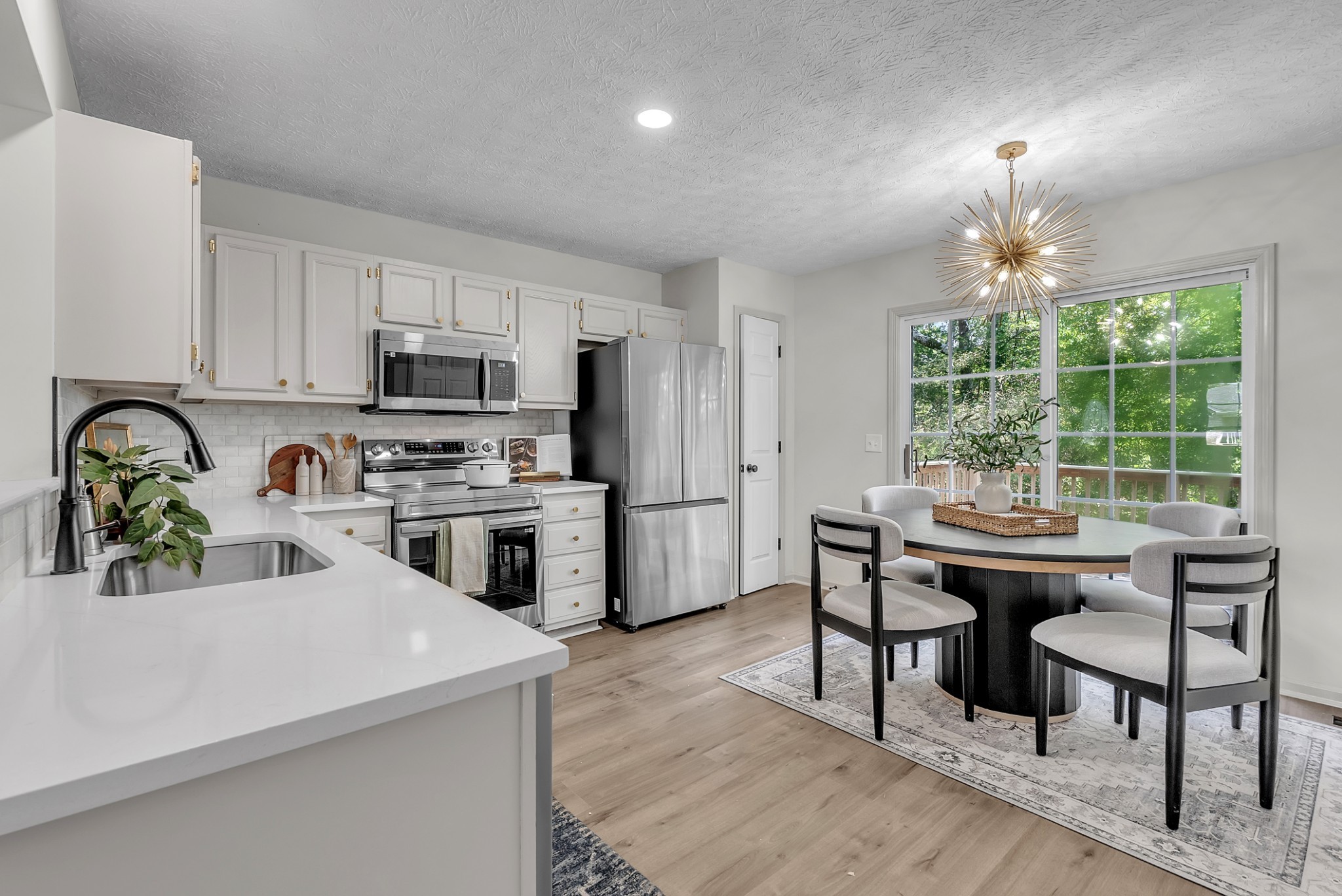 522 Acorn Way Mount Juliet, TN 37122 - Photo 9 of 30 a kitchen with a stove a sink a microwave a dining table and chairs