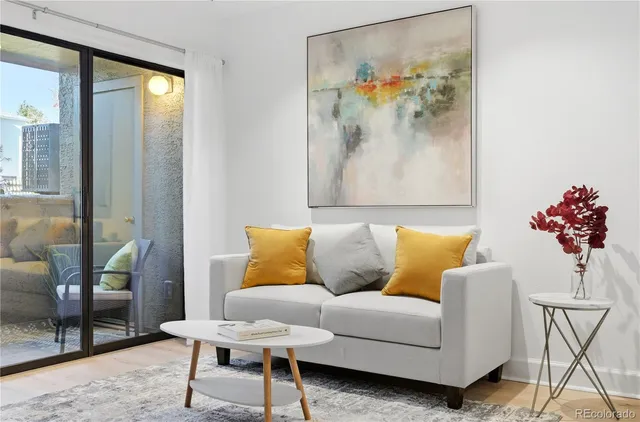 a living room with furniture and a painting on the wall