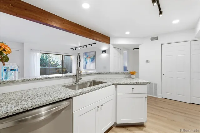 a bathroom with a granite countertop sink a mirror and a shower