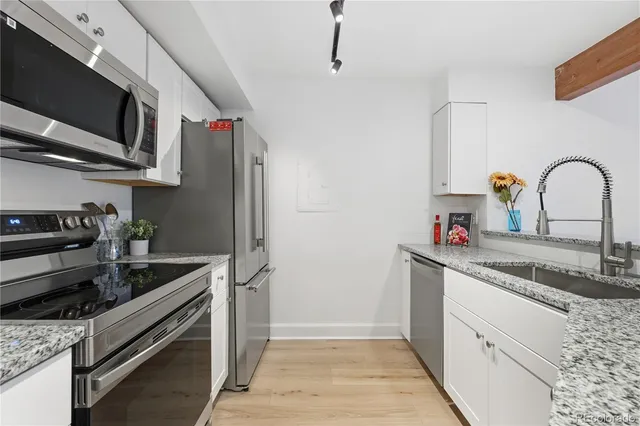a kitchen with stainless steel appliances granite countertop a sink and a stove