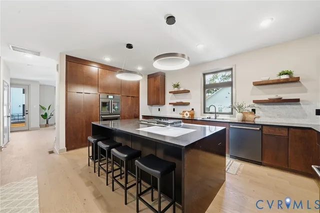 a kitchen with stainless steel appliances granite countertop a sink stove and refrigerator