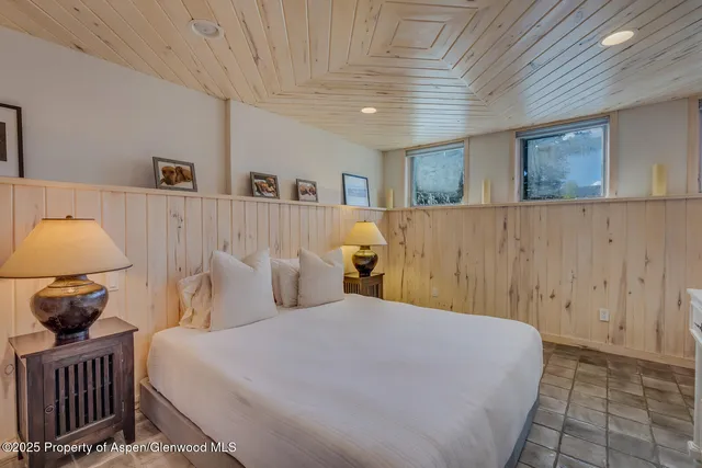 a bedroom with a bed and a lamp on dresser