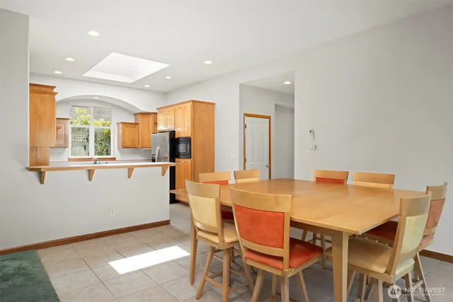 a dining table with a kitchen view and a refrigerator