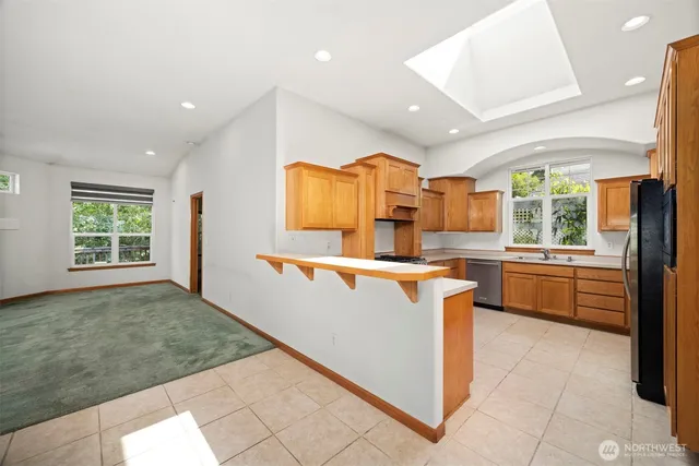 a kitchen with stainless steel appliances granite countertop a stove a sink dishwasher and a refrigerator