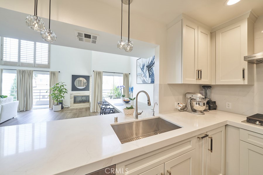 1617 South Beverly Glen Boulevard, Unit 303 Los Angeles, CA 90024 - Photo 15 of 55 a kitchen with kitchen island a sink a counter space cabinets and appliances