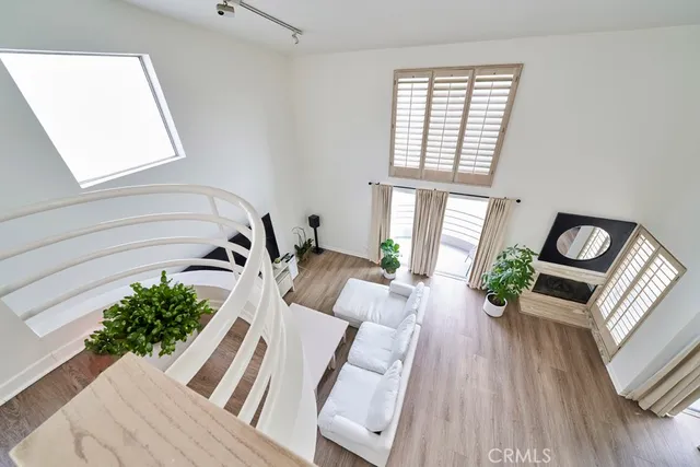 a living room with furniture floor to ceiling window and wooden floor