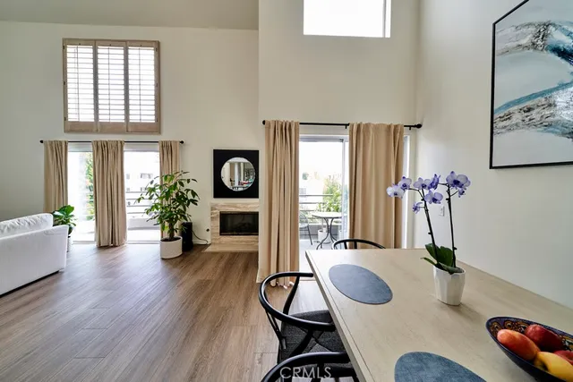 a dining room with furniture potted plants and wooden floor