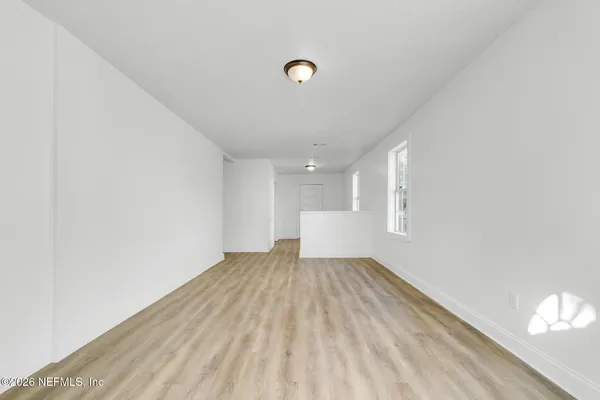 a view of a livingroom with wooden floor and a window