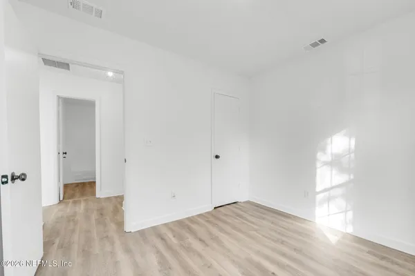 a view of empty room with wooden floor