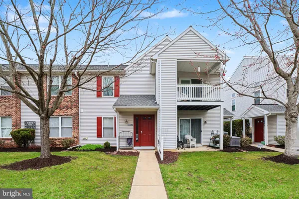 front view of a brick house with a yard