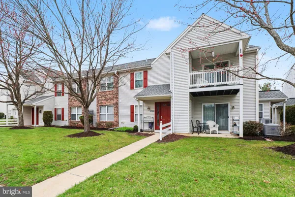 a front view of a house with a garden and trees
