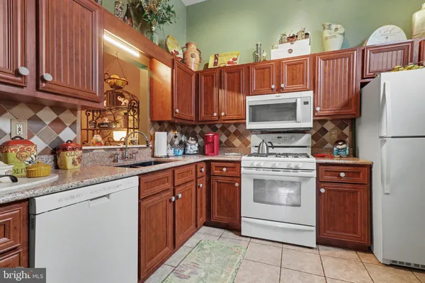 a kitchen with stainless steel appliances granite countertop a refrigerator sink stove microwave and cabinets