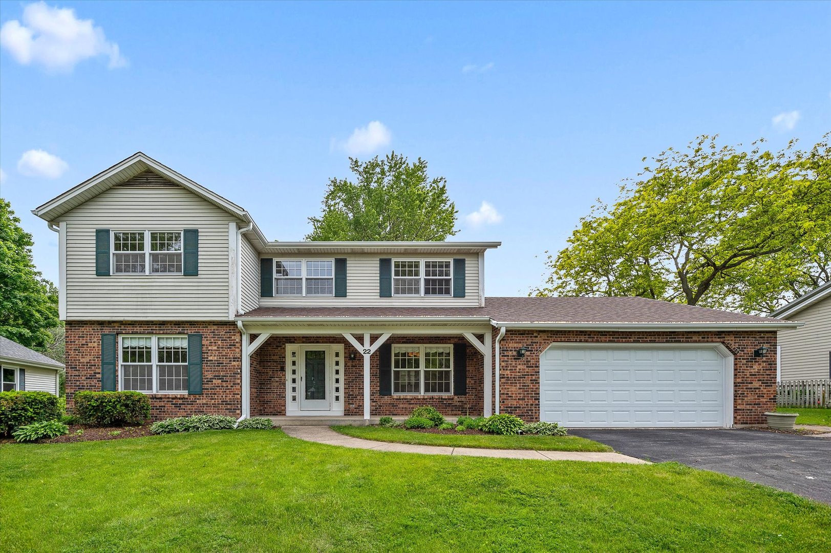 a front view of a house with a garden and trees