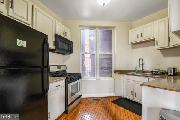 a kitchen with stainless steel appliances a sink a stove a microwave and refrigerator