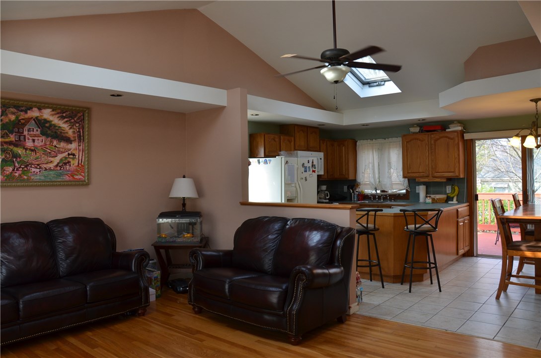 Open concept, hardwoods, tile, eat in kitchen with dining area, sliders to deck and side door.