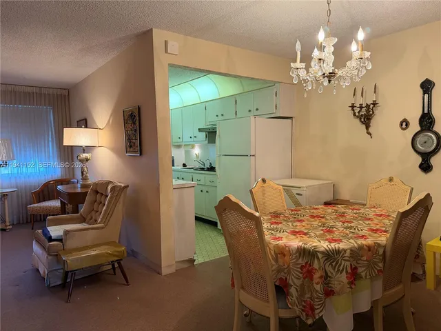 a view of a dining room with furniture and chandelier