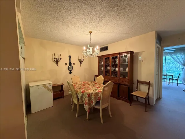 a view of a dining room with furniture and chandelier