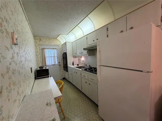 a kitchen with cabinets a refrigerator and a stove