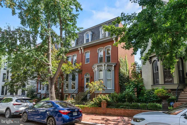 a front view of a building with trees