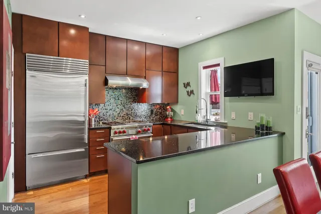 a kitchen with kitchen island granite countertop a sink stove and refrigerator