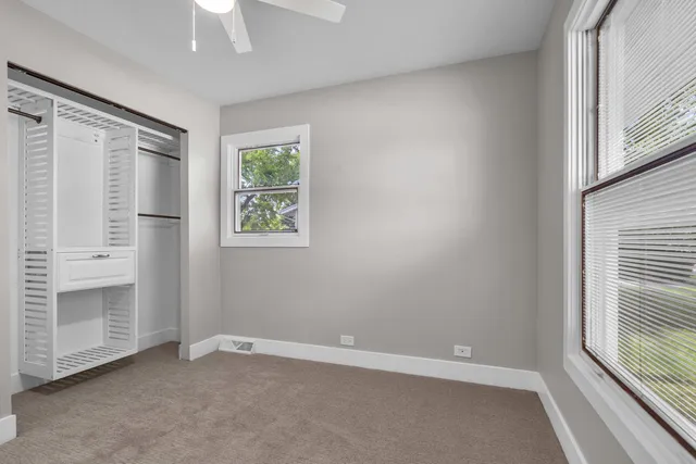 an empty room with windows and closet