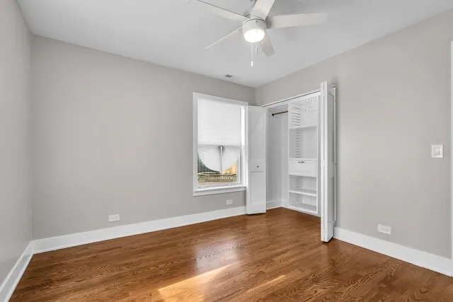 an empty room with wooden floor and window