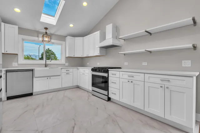 a kitchen with white cabinets stainless steel appliances and sink